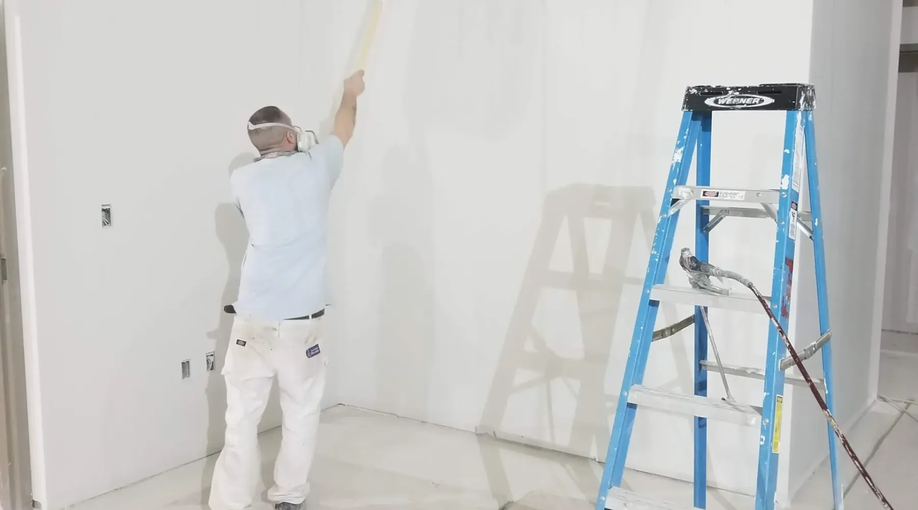 JMU painter applying paint to an interior wall