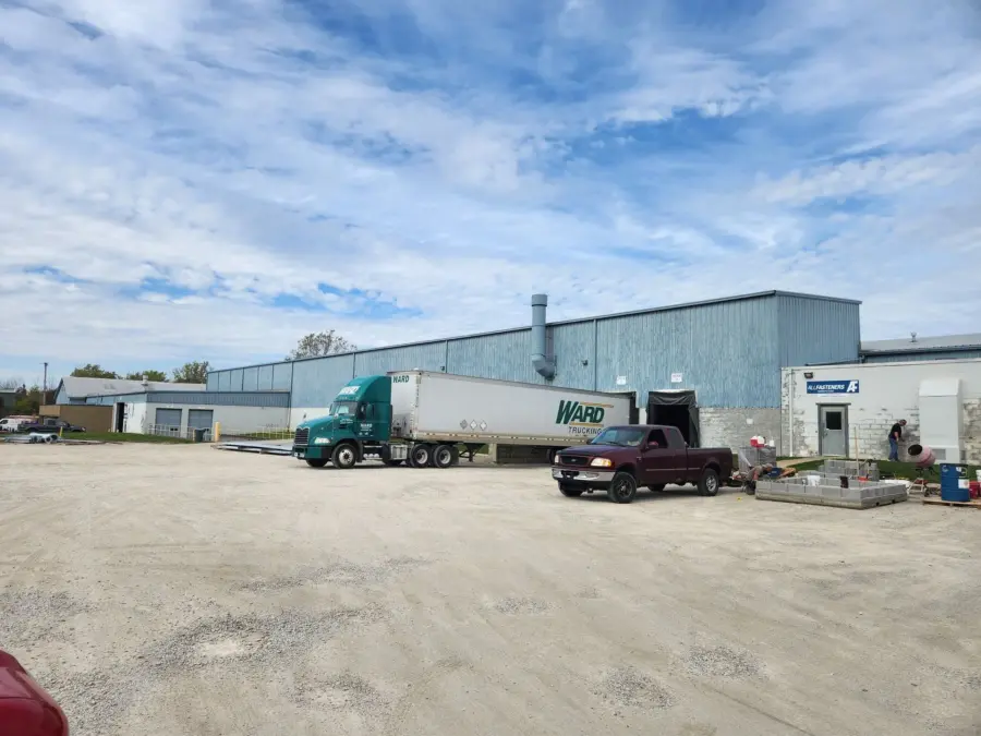 A truck is parked in front of a large building.