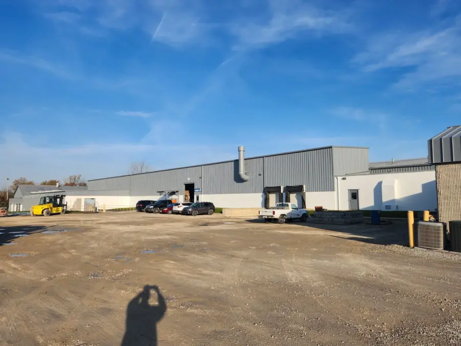 A large building with a lot of cars parked in front of it.