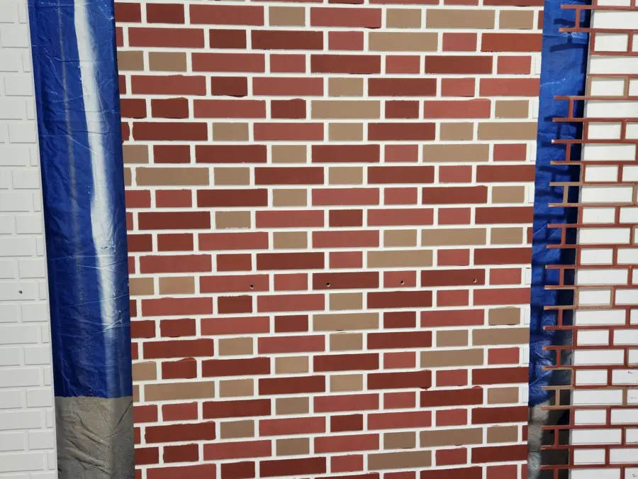 A brick wall with a blue tarp covering it