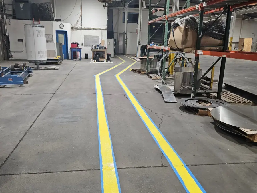 A warehouse with yellow and blue lines on the floor