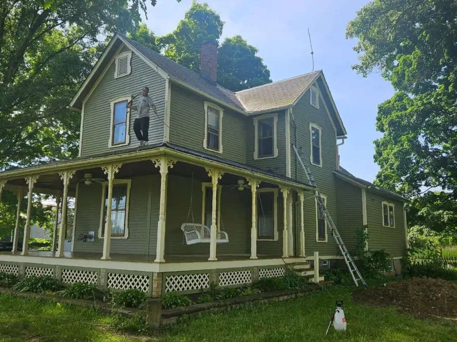 A man is standing on the porch of a house