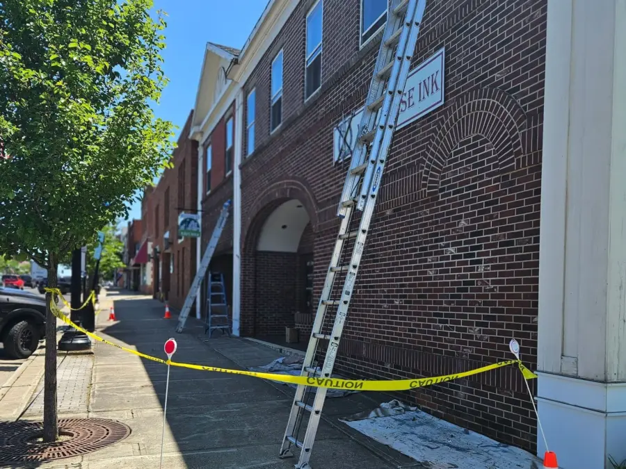 A ladder is leaning against a brick building with a sign that says police