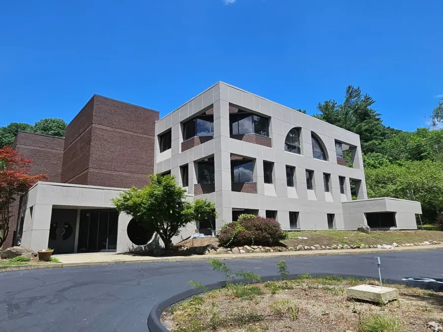 A large building with a lot of windows and trees in front of it.