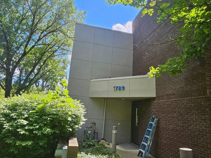 A large brick building with a ladder in front of it.