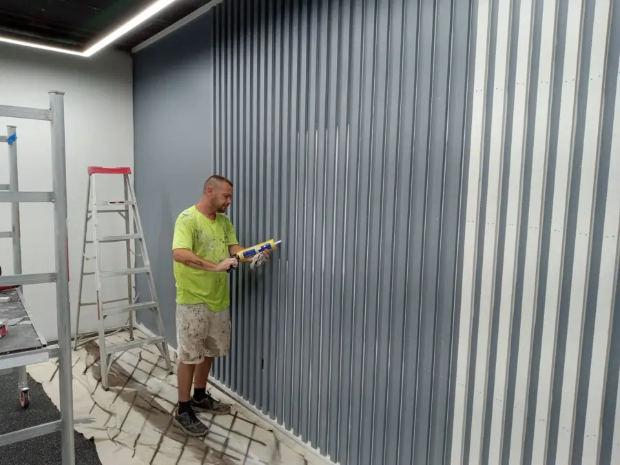 A man is painting a wall with a brush.