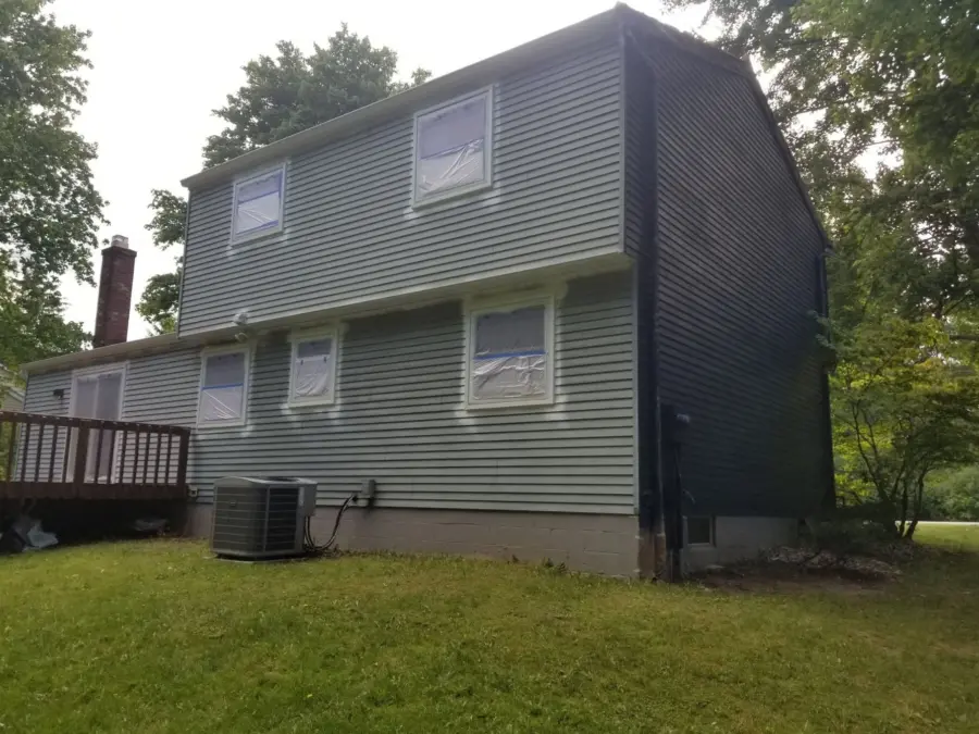 A large house with a lot of windows and a deck in the backyard.