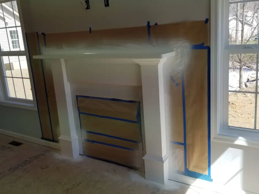 A fireplace is being painted in a living room